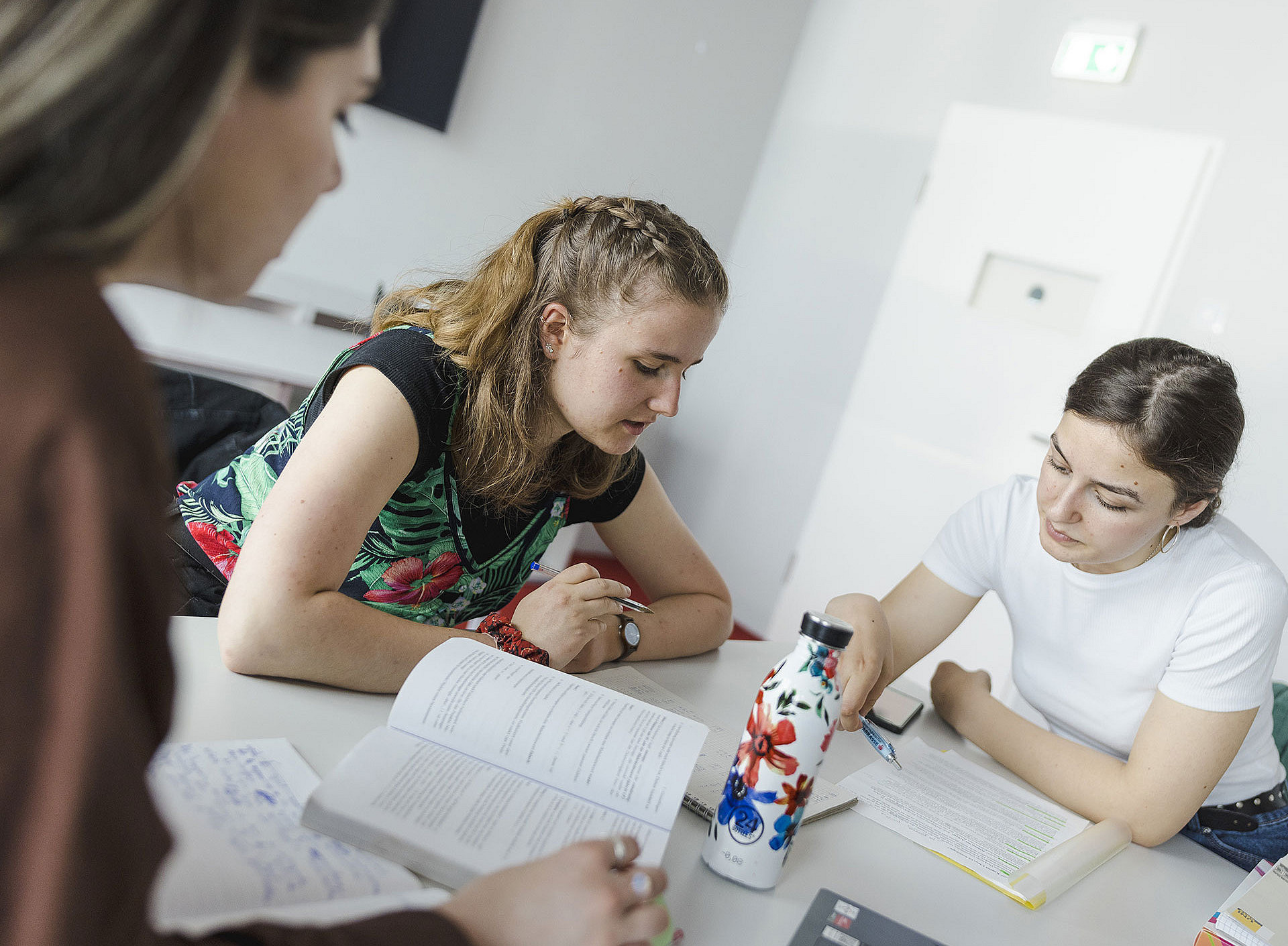 Drei Studierende sitzen gemeinsam am Tisch und lernen ©Uni Graz/Kanizaj
