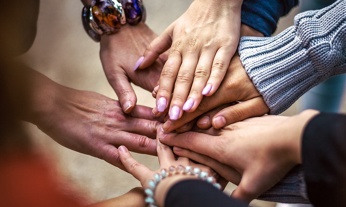 Menschen legen ihre Hände übereinander. Foto: pixabay