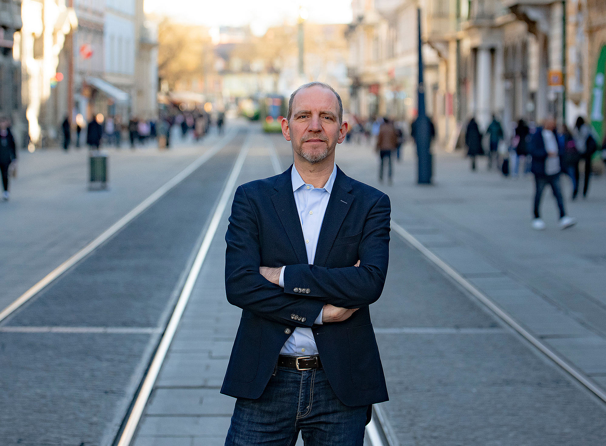 Florian Bieber mitten in der Grazer Herrengasse, stehend, die Arme verschränkt ©Uni Graz/Tzivanopoulos