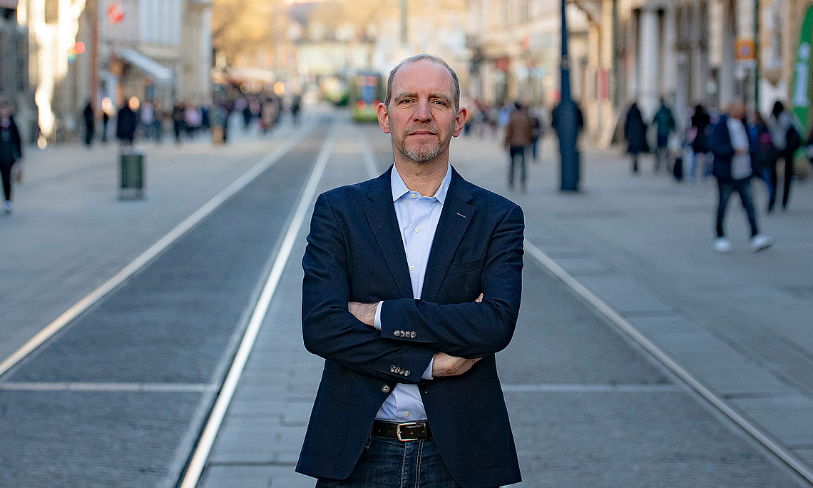 Florian Bieber in the middle of Herrengasse in Graz, standing, arms folded