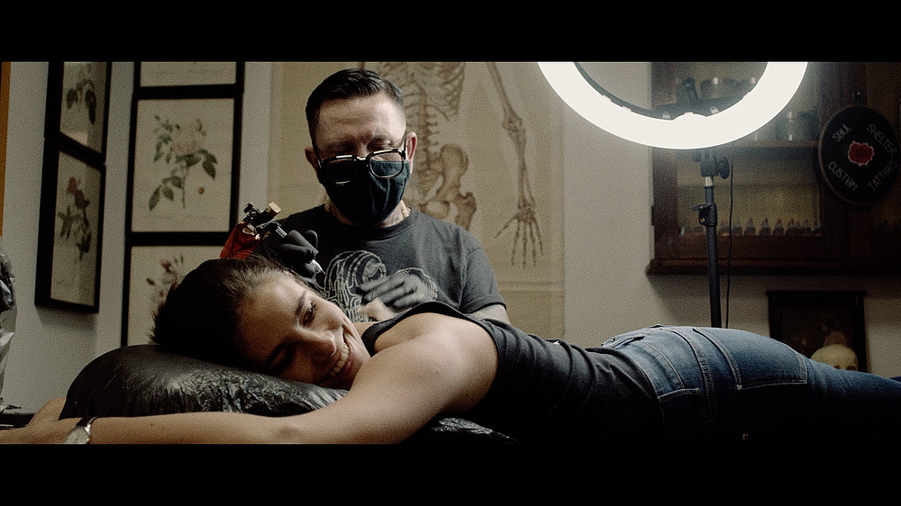 Ein nTätowierer tätowiert eine Kundin, die auf der Liege liegt. ©CC-BY 4.0 Int., Science Ink