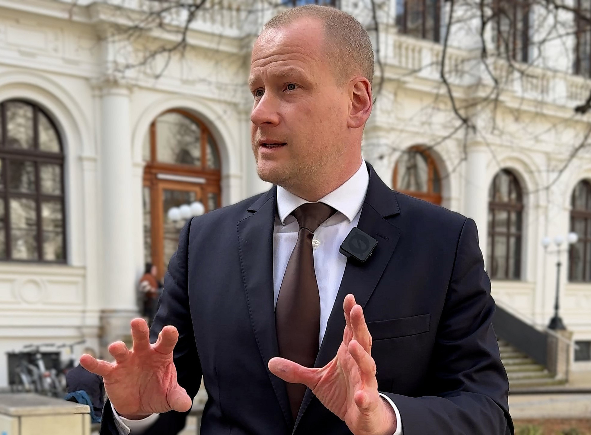 Christoph Bezemek gestikuliert im Innenhof der Universität Graz 