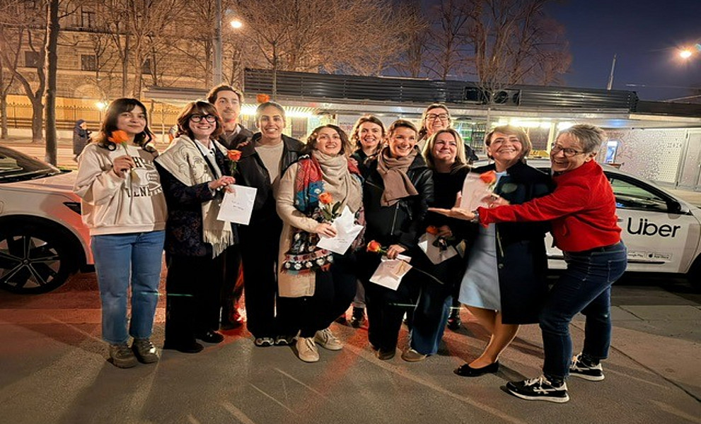 Eine Gruppe von Frauen steht vor einem Auto