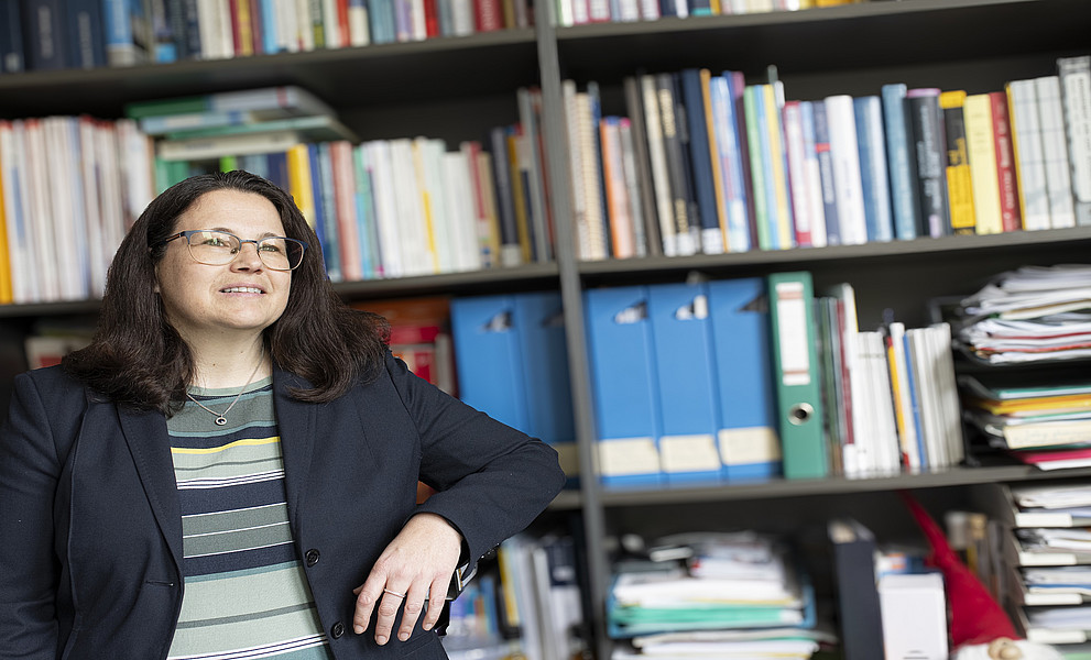 Eine Frau lehnt an einem Bücherregal