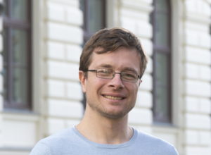 Ein Mann steht vor einem Gebäude 