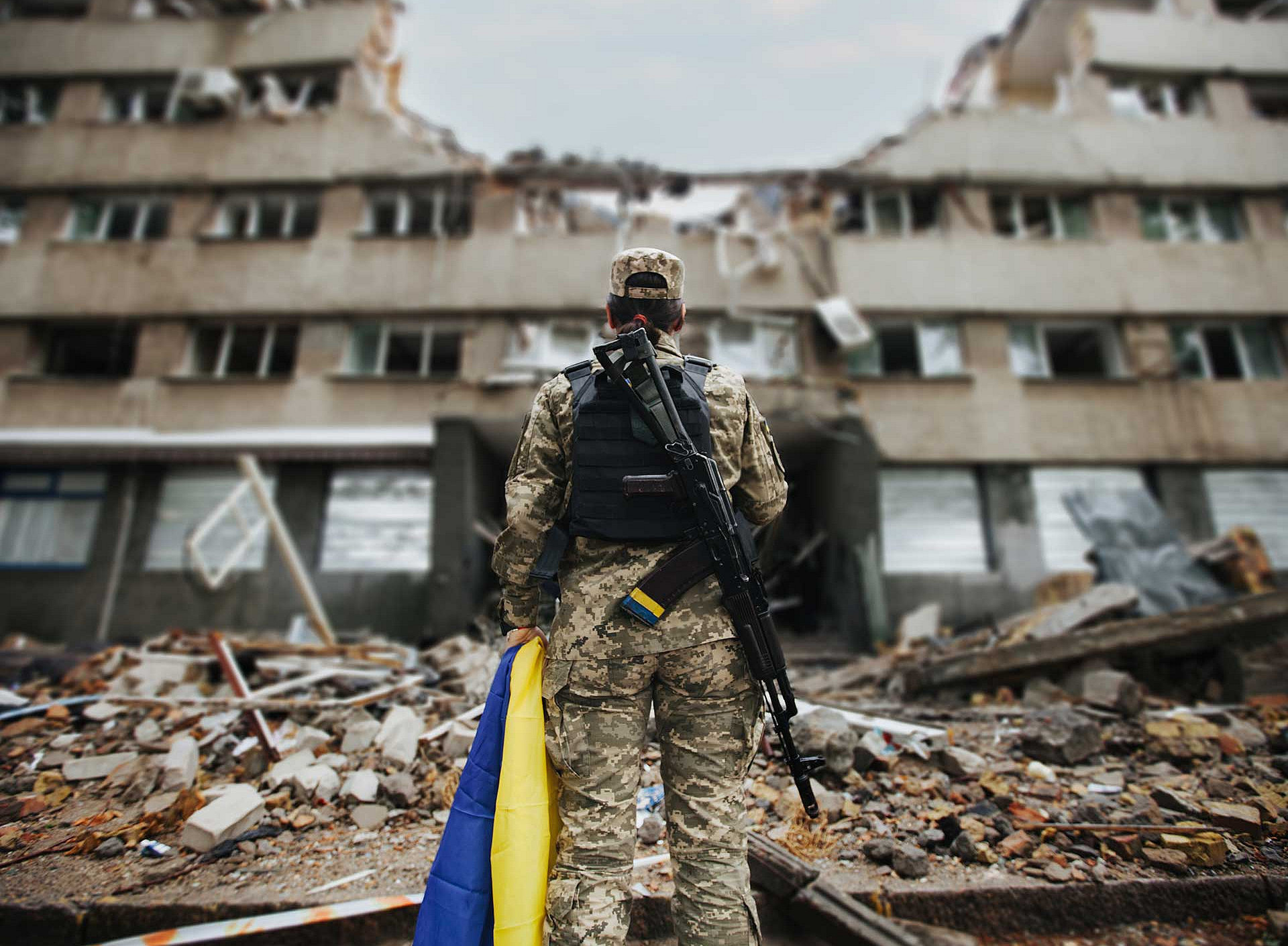 Soldatin vor zerstörtem Gebäude 