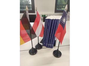 die Fahnen der drei Länder vor Ausgaben der Tagungsbände vom letzten Jahr ©Stefan Storr