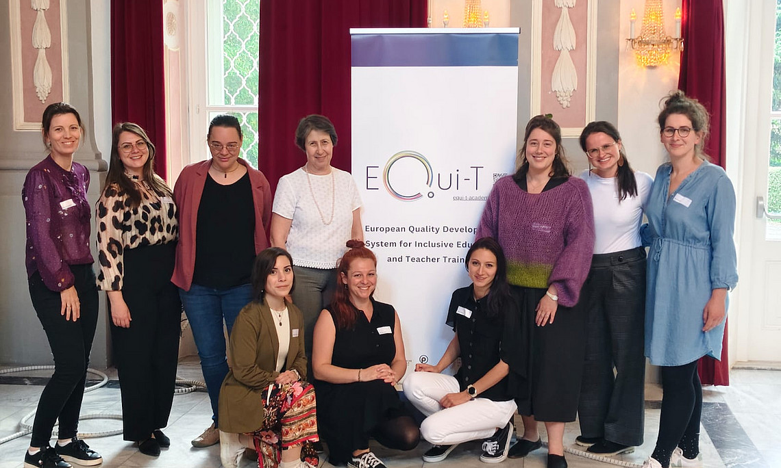 Foto: Das österreichische EQui-T Projektteam vor einem Rollup mit der Aufschrift "EQui-T"