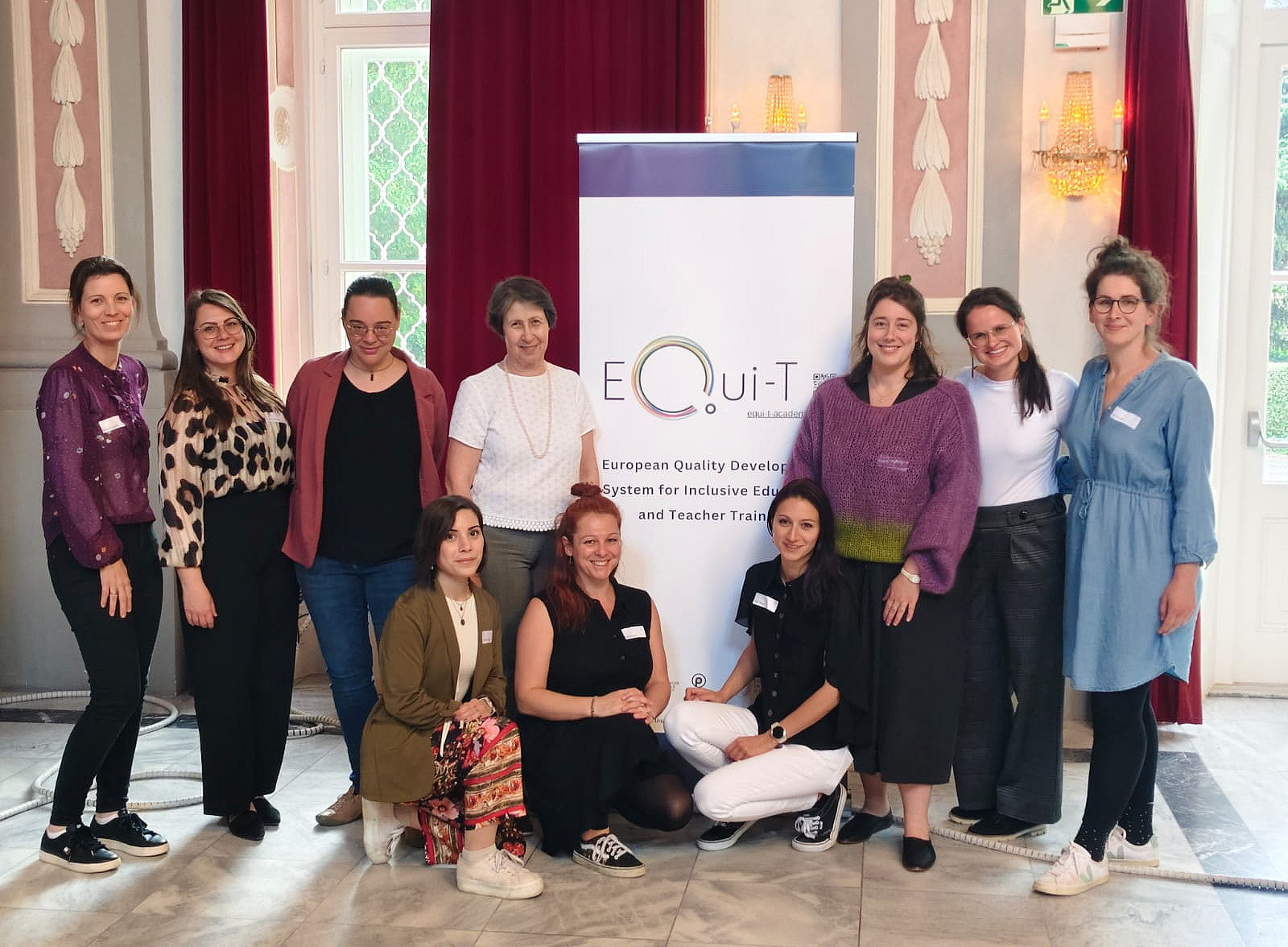 Foto: Das österreichische EQui-T Projektteam vor einem Rollup mit der Aufschrift "EQui-T" 