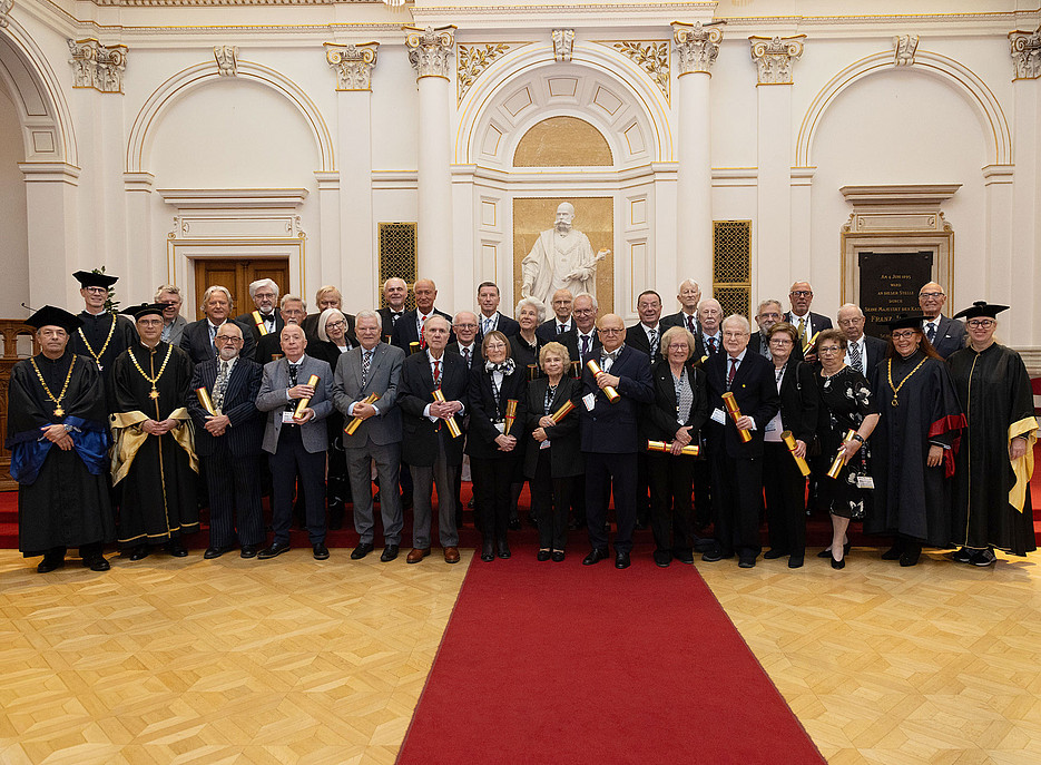 Goldene Promotion 2025 in der Aula der Uni Graz: Gruppenfoto der Absolvent:innen der Rechtswissenschaften, Geisteswissenschaften, Umwelt-, Regional- und Bildungswissenschaften, Rektor, Vizerektorin und Dekan:innen ©Uni Graz / Foto Gasser
