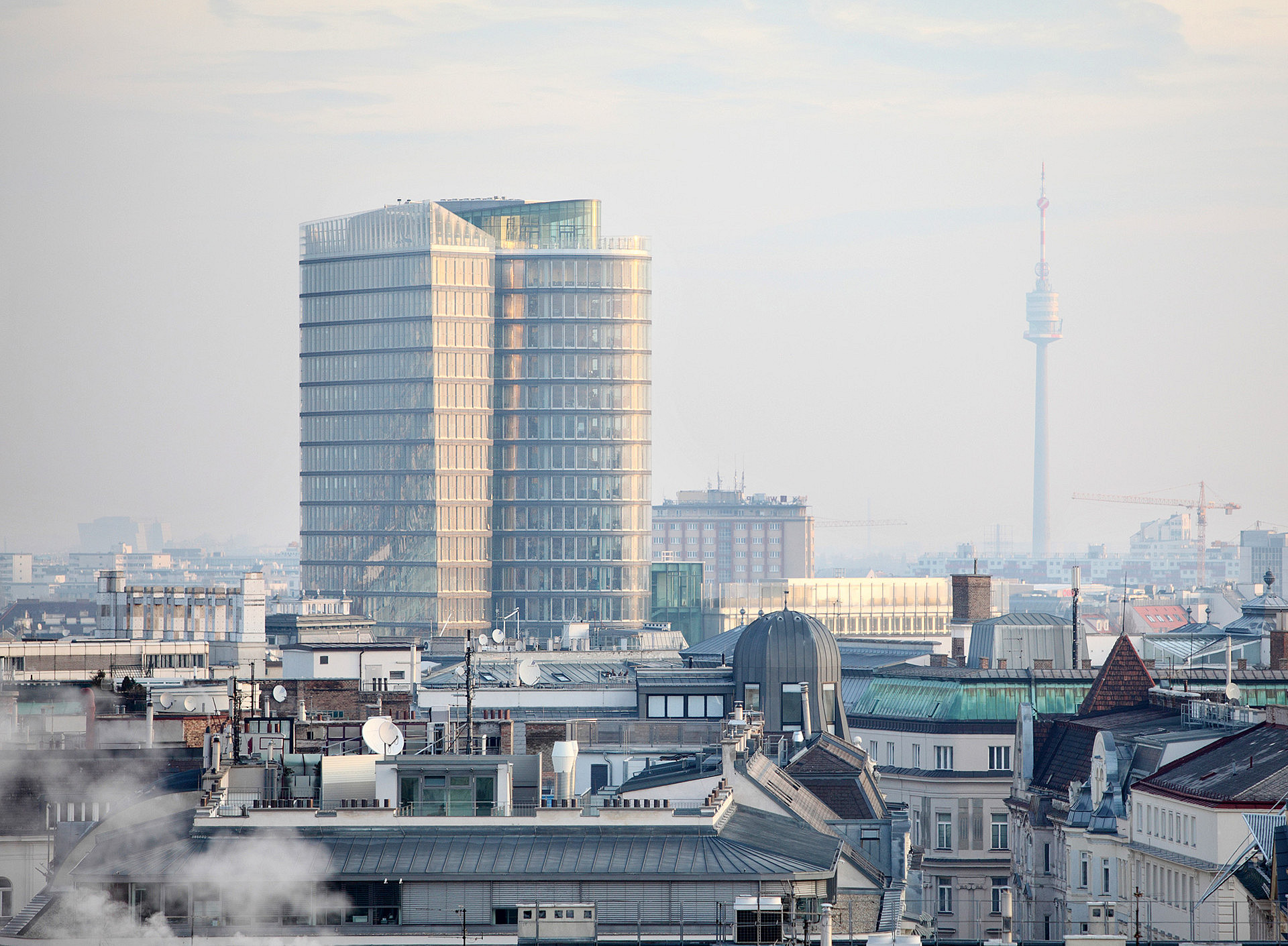 Blick von oben auf Wien mit dem UNIQA Tower, Dunst in der Luft, im Vordergrund etwas Rauch ©Losevsky Pavel - stock.adobe.com