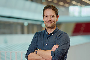 Paul Gragl with folded arms in the Graz University Library