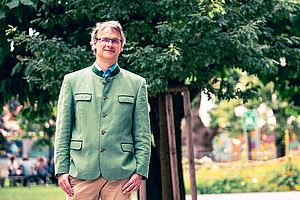 Chemiker Wolfgang Kroutil vor einem Baum am Campus der Universität Graz