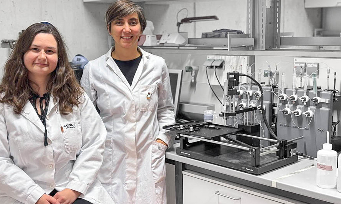 Two women are standing in a lab