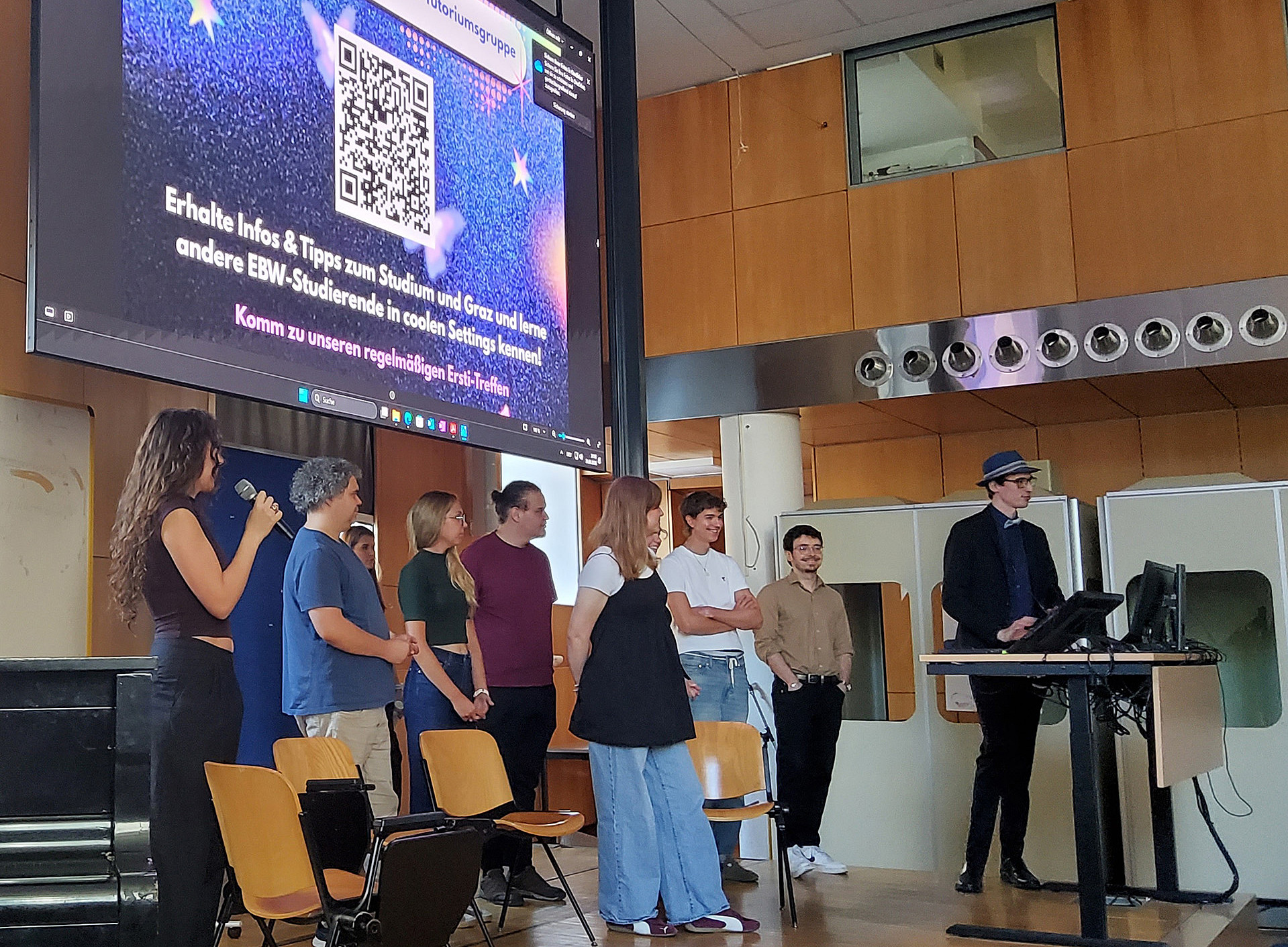 9 Studierende stehen auf einer Bühne und halten eine Präsentation ©Uni Graz/Bachmann