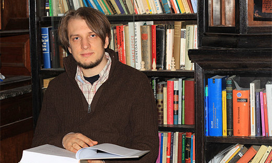 Jakob Reichsöllner mit seiner Masterarbeit. Es ist die achte in der Sammlung der Deutschen WortSchätze.