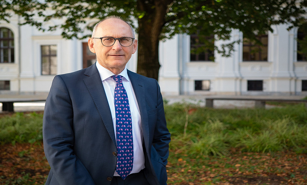 Gerhard Schnedl im Innenhof des Uni-Graz-Hauptgebäudes vor der Linde