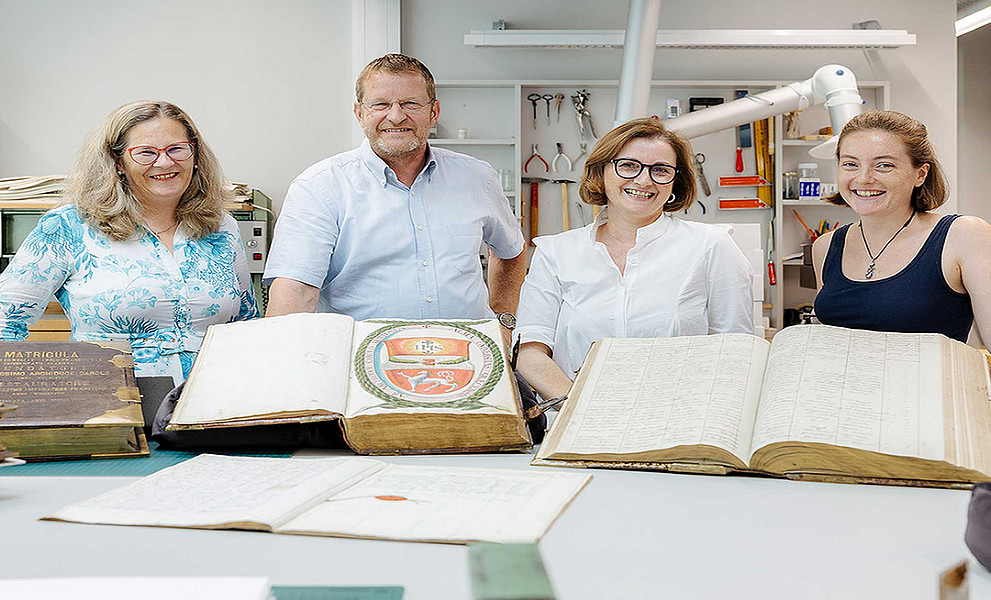 Freuen sich über die fertig restaurierten Universitätsmatrikel (v. l.): Pamela Stückler, Leiterin der Universitätsbibliothek Graz, Ralph Zettl, Vorstandsvorsitzender des alumni UNI graz, Theresa Zammit Lupi, leitende Restauratorin in den Sondersammlungen der Universitätsbibliothek Graz und Restauratorin Lena Krämer, die den Großteil dieser Restaurierung durchgeführt hat. Foto: Uni Graz/Marija Kanizaj