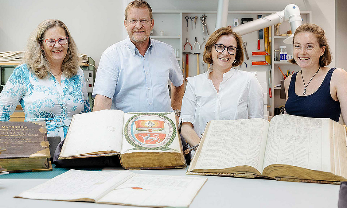Freuen sich über die fertig restaurierten Universitätsmatrikel (v. l.): Pamela Stückler, Leiterin der Universitätsbibliothek Graz, Ralph Zettl, Vorstandsvorsitzender des alumni UNI graz, Theresa Zammit Lupi, leitende Restauratorin in den Sondersammlungen der Universitätsbibliothek Graz und Restauratorin Lena Krämer, die den Großteil dieser Restaurierung durchgeführt hat. Foto: Uni Graz/Marija Kanizaj