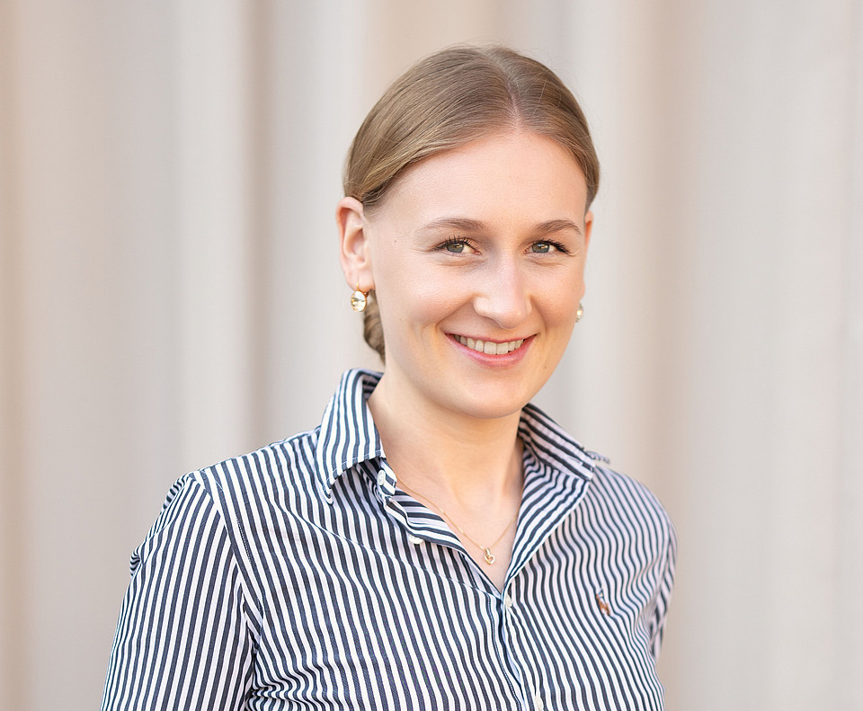 Porträtaufnahme von Viktoria Hödl, einer BWL-Absolventin der Uni Graz, in einem längsgestreiften Hemd.