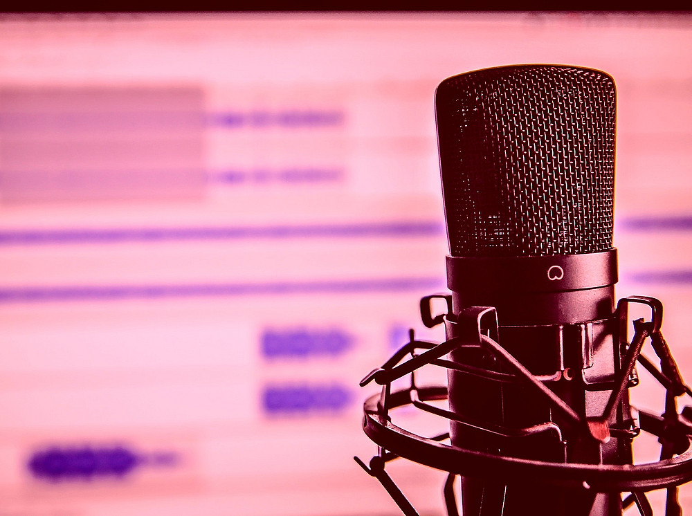Podcast microphone in front of a pink background ©Pixabay/Daniel Friesenecker