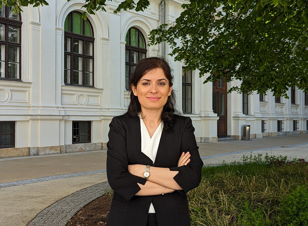 A woman is standing in front of a tree 