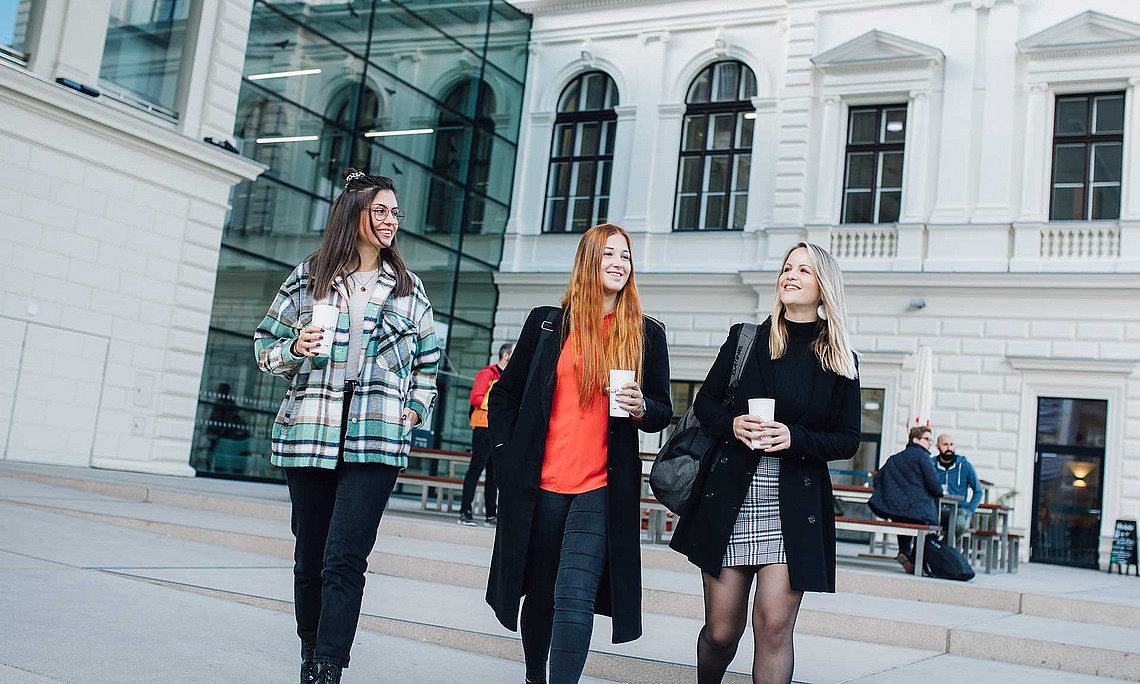 Drei Studentinnen vor der Bibliothek
