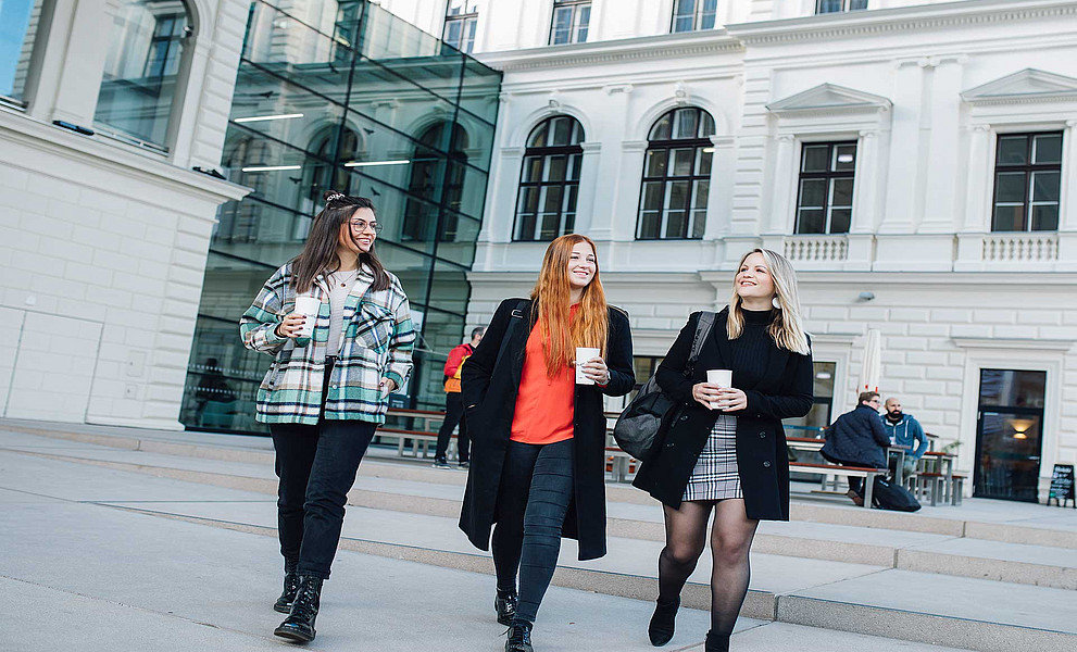 Drei Studentinnen vor der Bibliothek