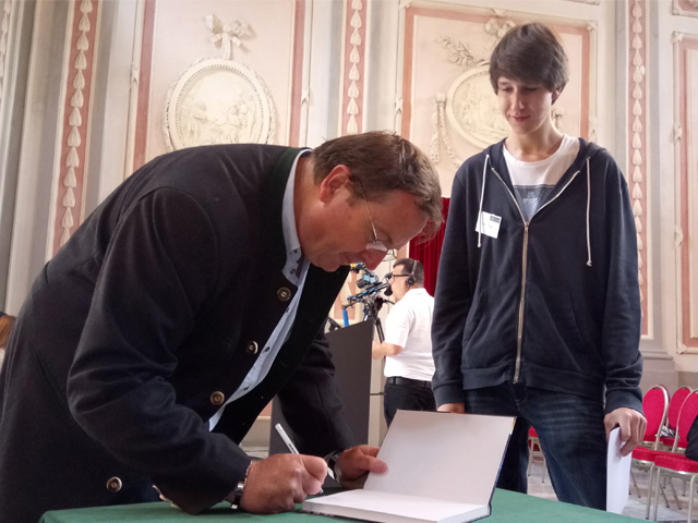 Arnold Hanslmeier signiert Bücher für Preisträger. Foto: IGAM/Maderbacher 