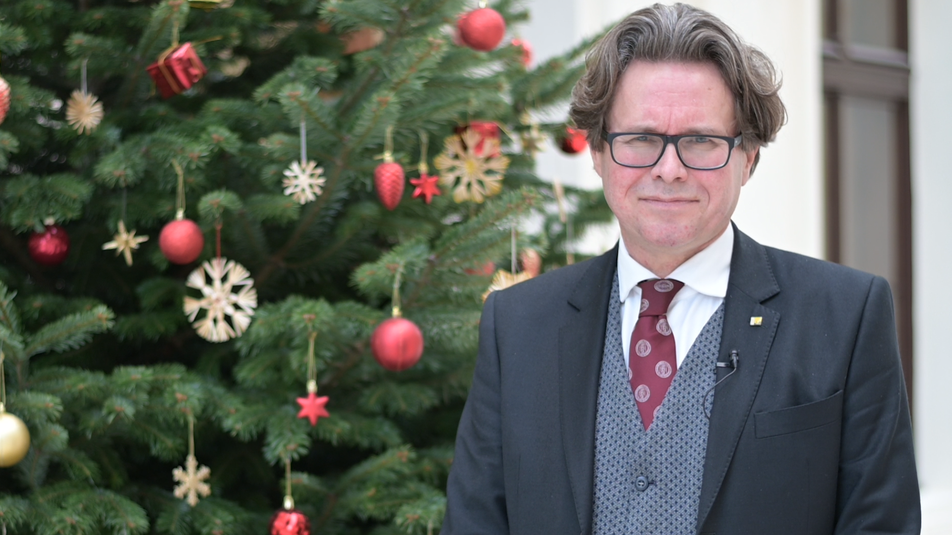 Rektor Polaschek mit Weihnachtswünschen aus dem Foyer der neuen Universitätsbibliothek. Foto: Koppelhuber/Uni Graz 