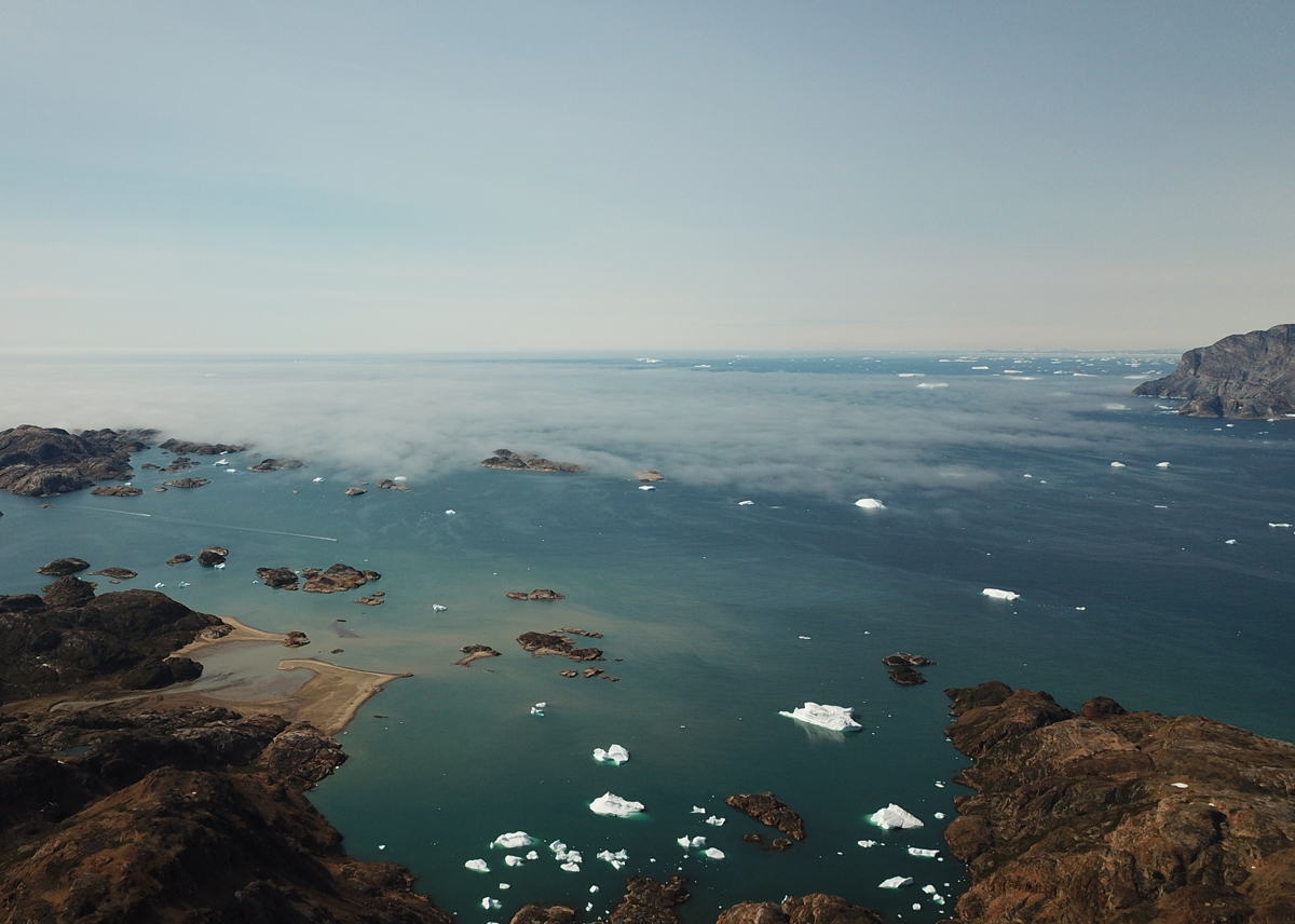 Der Ammassalikfjord, Ostgrönland. Die Schichtbewölkung in tiefen Lagen deutet auf eine Inversionsschicht hin, die den Luftaustausch mit höheren Schichten reduziert. Foto: Uni Graz/Abermann 