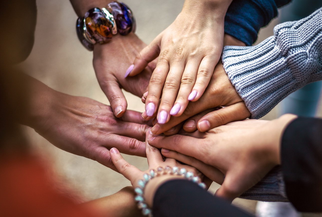 Menschen legen ihre Hände übereinander. Foto: pixabay 