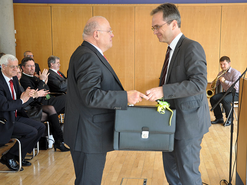 Eine Tasche für viele Ideen überreichte Vizerektor Riedler an Dekan Marko. 