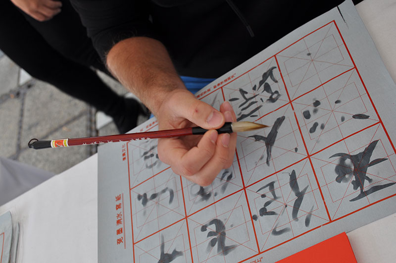 BesucherInnen können sich in Kalligraphie und Scherenschnitt versuchen. 