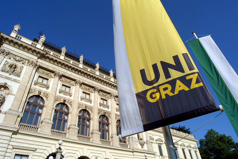 Hauptgebäude der Uni Graz mit Fahnen 