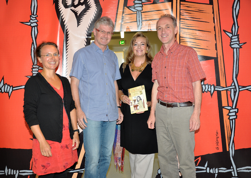 Ursula Jungmeier-Scholz, Nikolaus Reisinger (v.l.) und Franz Stangl (r.) vom UniGraz@Museum überreichten ihrer 10.000 BesucherIn, Sabina Prisender, eine Publikation zu Anne Frank als Geschenk. 