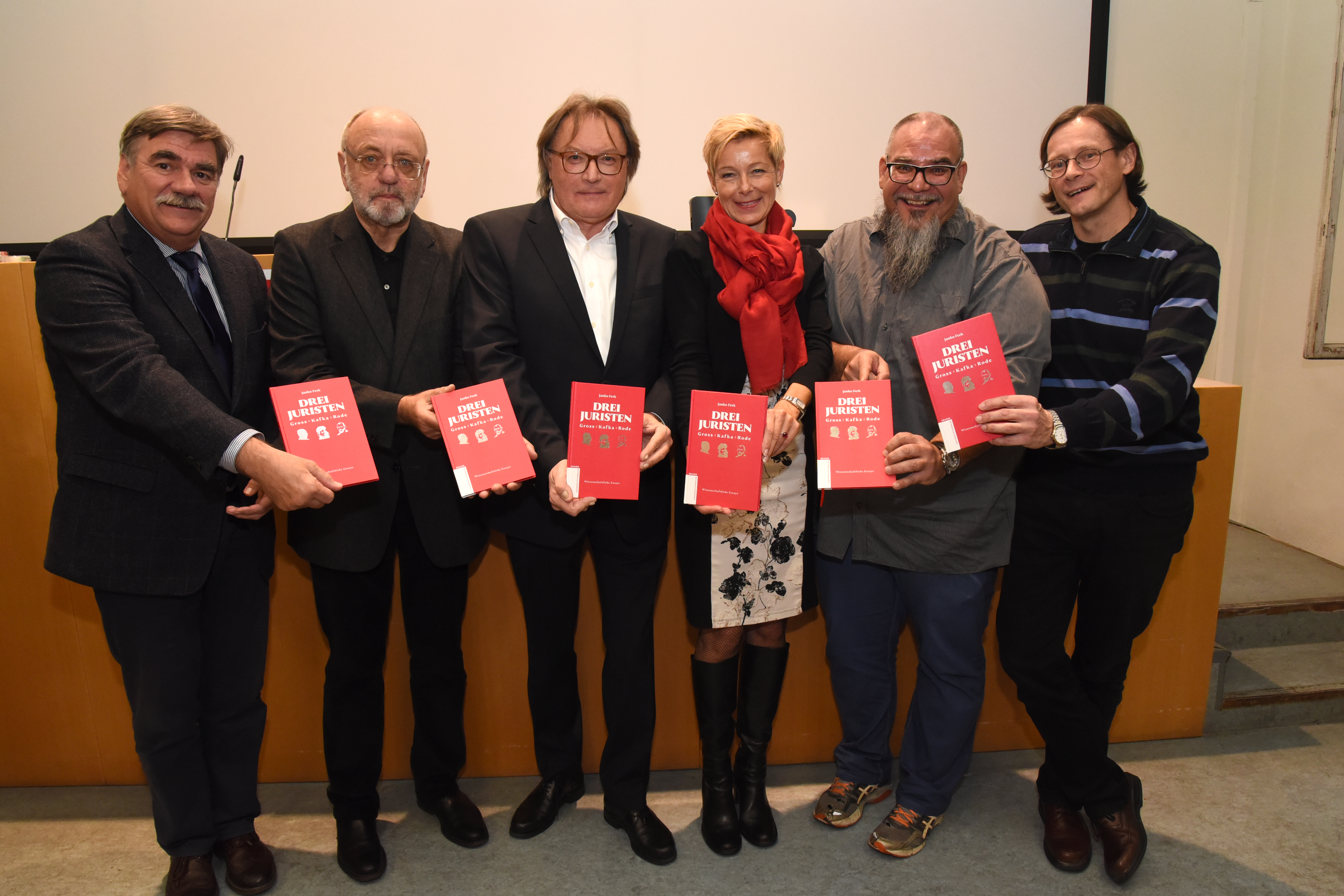 „3 Juristen“: Werner Schlacher, Gerhard Dienes, Jano Ferk, Elisabeth Klöckl-Stadler, Roman Klug und Christian Bachhiesl mit dem neuesten Werk aus dem Grazer Universitätsverlag (v.l.) ©Uni Graz/Schweiger